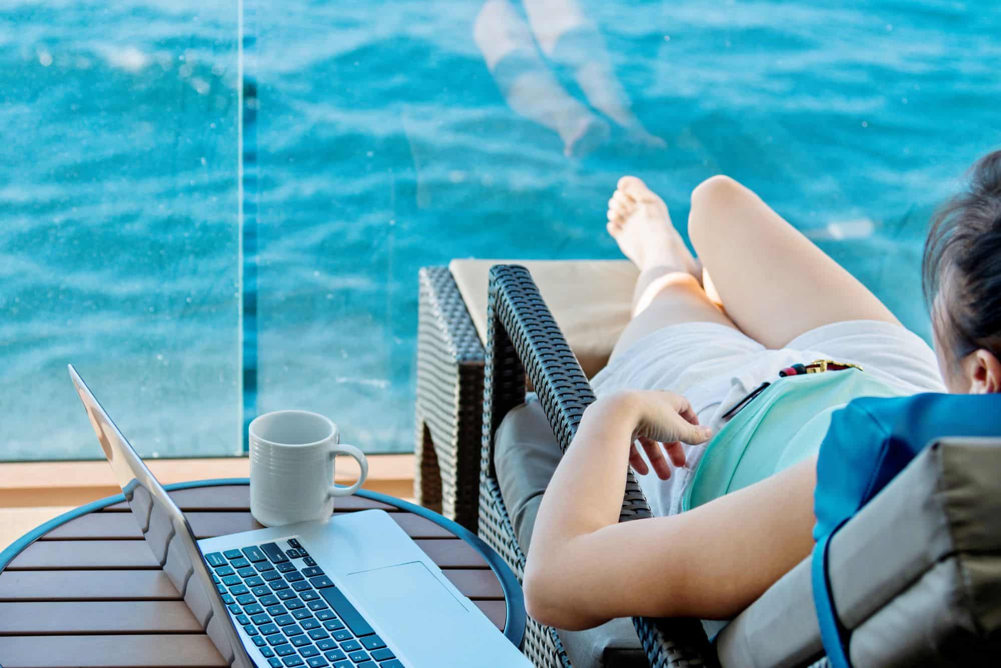 Stock photo of woman working remotely from a cruise ship balcony