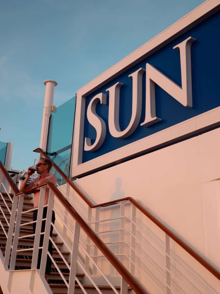 Owen drinking a cocktail out at sunset onboard Sun Princess